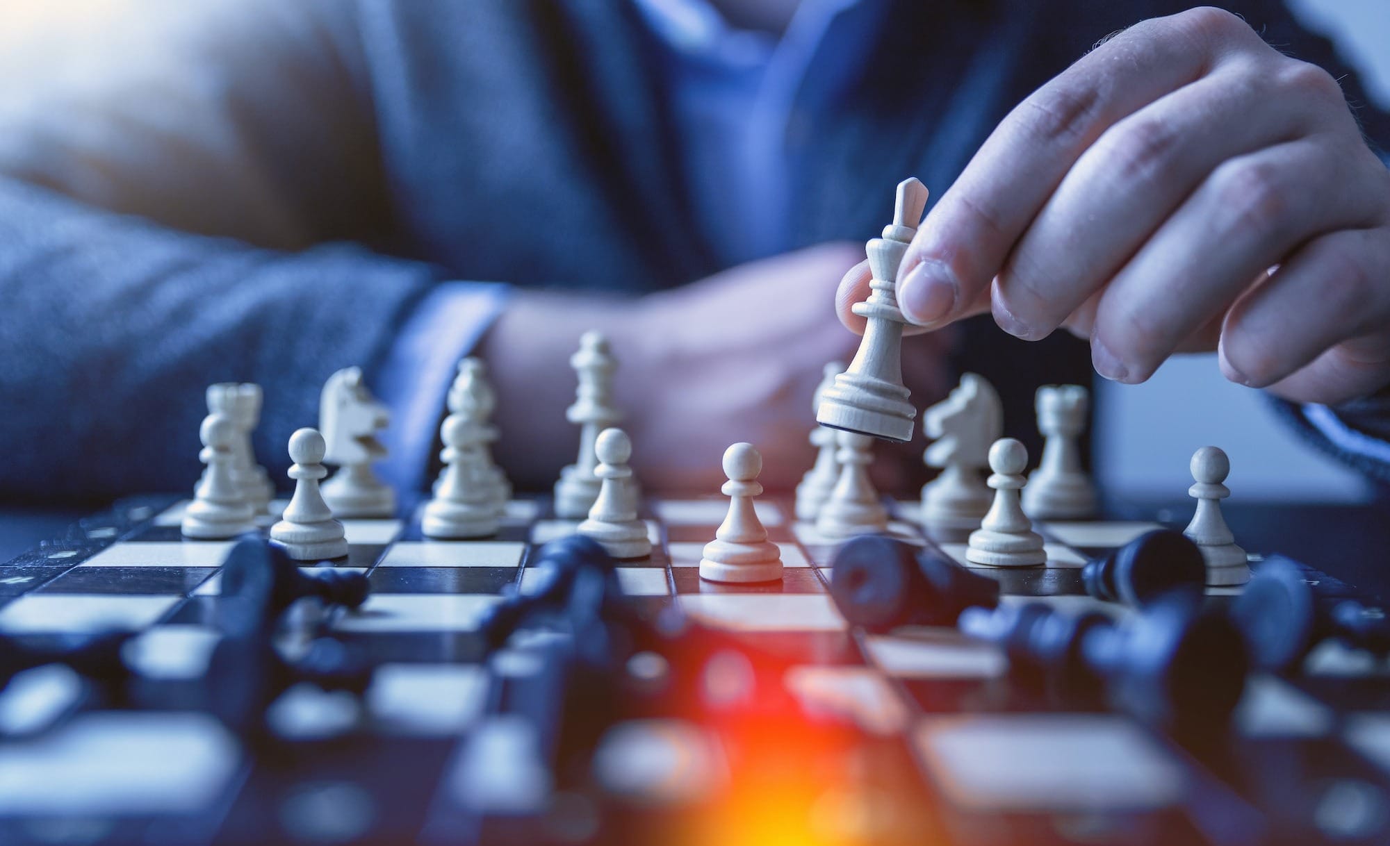 depth of field photography of man playing chess